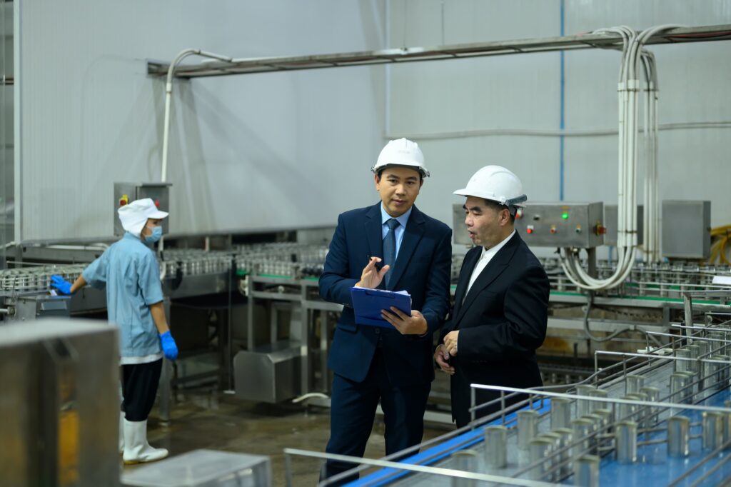 Two business professionals reviewing operations in a food production facility